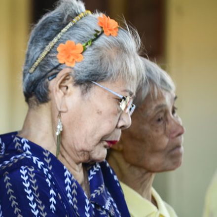 An elderly woman with flowers in her hair