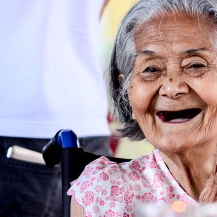 An elderly woman laughing with joy