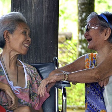 Two elderly women laughing together